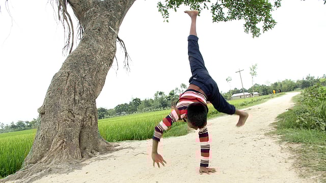 মেঠো পথে ডিগবাজি দিচ্ছে এক কিশোর। ছবিটি আজ বৃহস্পতিবার বগুড়ার শিবগঞ্জ উপজেলার নিশ্চিন্তপুর গ্রাম থেকে তোলা। ছবি: সোয়েল রানা