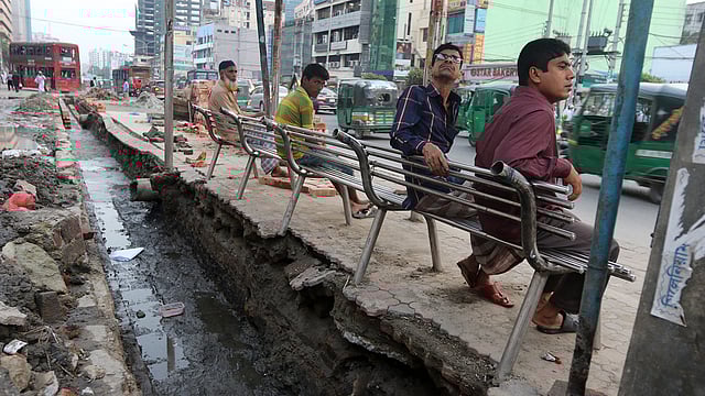 রাজধানীর কাজী নজরুল ইসলাম অ্যাভিনিউয়ের কারওয়ান বাজার অংশের ওয়াকওয়ের এক পাশ কেটে রেখেছে ঢাকা উত্তর সিটি করপোরেশন। কিন্তু যাত্রী ছাউনিটি সরানো হয়নি। ফলে ঝুঁকিপূর্ণ অবস্থায় রয়েছে যাত্রী ছাউনিটি। ঝুঁকি নিয়েই এখানে বসছে সাধারণ মানুষ। ছবিটি আজ বৃহস্পতিবার বিকেলে তোলা। ছবি: আবদুস সালাম