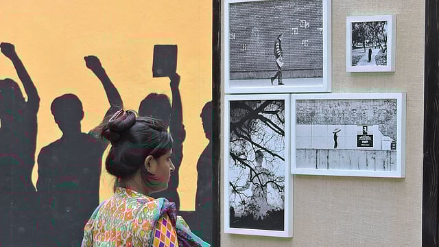 ঢাকা ইউনিভার্সিটি ফটোগ্রাফি সোসাইটির দশম বার্ষিক প্রদর্শনীতে আলোকচিত্র দেখছেন একজন দর্শনার্থী l ছবি: প্রথম আলো