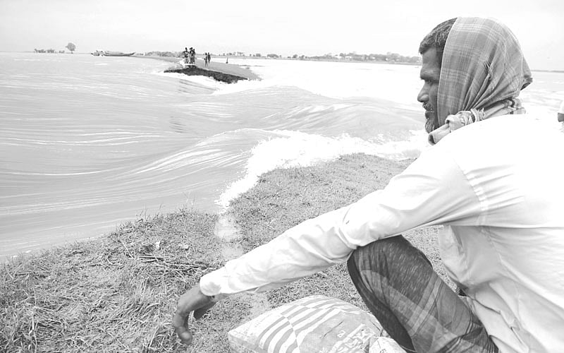 ফসলহারা এবং ভাঙনের বিরুদ্ধে লড়াইয়ে পরাজিত নিঃস্ব কৃষকের বসে থাকা l ছবি: প্রথম আলো