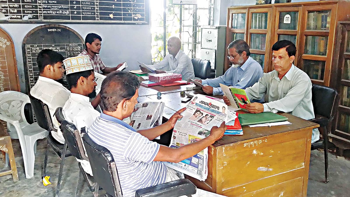 আনোয়ারার শিলাইগড়া গণপাঠাগারে পত্রিকা পাঠে মগ্ন পাঠকেরা। ছবিটি সম্প্রতি তোলা l প্রথম আলো