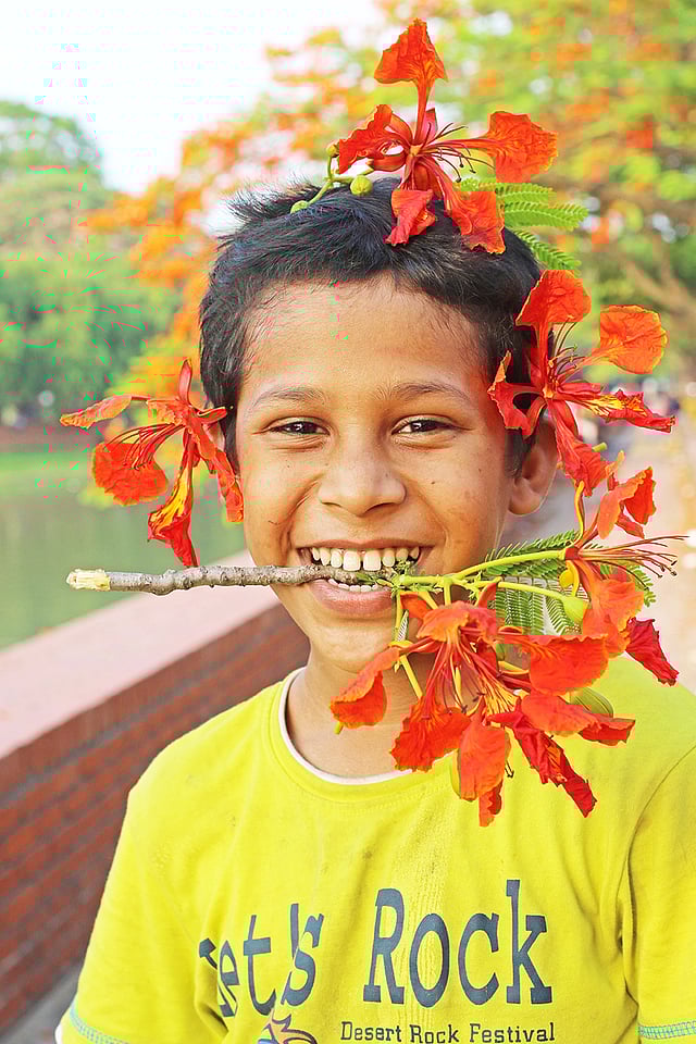 কৃষ্ণচূড়া ফুল দিয়ে মজার সাজে ছেলেটি। ছবি: সাবিনা ইয়াসমিন