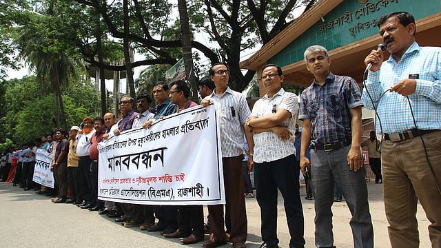 চিকিৎসকের ও চিকিৎসা প্রতিষ্ঠানের ওপর হামলার প্রতিবাদে এবং দোষী ব্যক্তিদের শাস্তির দাবিতে রাজশাহী মেডিকেল কলেজের সামনে মানববন্ধন করেছে বিএমএ রাজশাহী শাখা। ছবিটি রোববার দুপুরে তোলা। ছবি: শহীদুল ইসলাম