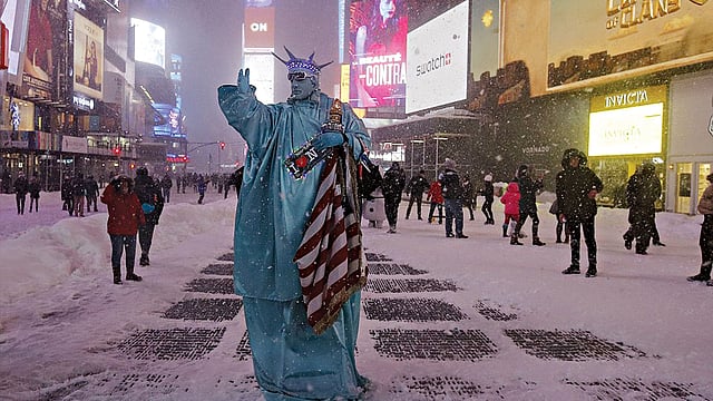 টাইমস স্কয়ারে গভীর রাতে স্টাচু অব লিবার্টির সাজে এক ব্যাক্তি l রয়টার্স
