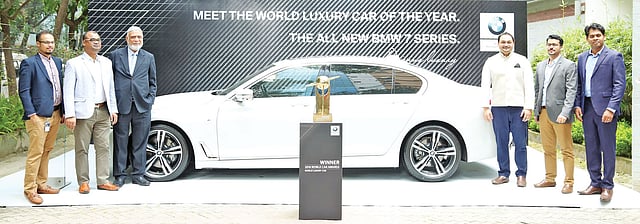 বিএমডব্লিউ সেভেন সিরিজ মডেলের গাড়ির পাশে এক্সিকিউটিভ মোটরসের কর্মকর্তারা