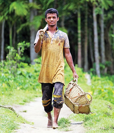 রাস্তা নেই বা রাস্তা খারাপ—খবর পেলেই কোদাল-টুকরি হাতে ছুটে যান সুমন মিয়া। ছবি: আনিস মাহমুদ
