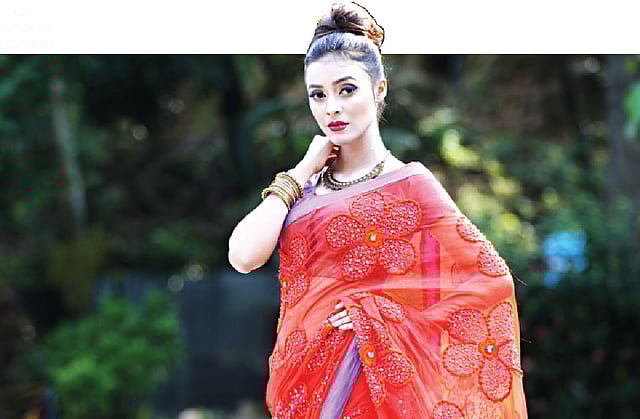 উৎসবে নারীর প্রধান পোশাক শাড়ি। মসলিনের শাড়ির জমিনে হাতের কাজ। লাল রঙে বেগুনি চিকন পাড় নজরকাড়া। শাড়ি ক বিভাগের দ্বিতীয় হয় ফ্যাশন হাউস ডিজাইন বাই রুবিনা। মডেল: সাবরিন