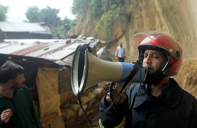 পাহাড়ের পাদদেশে ঝুঁকিপূর্ণভাবে বসবাসকারীদের সরে যেতে জেলা প্রশাসনের পক্ষ থেকে মাইকিং করা হচ্ছে। ছবিটি মঙ্গলবার দুপুরে চট্টগ্রাম নগরের মতিঝর্না এলাকা থেকে তোলা। ছবি: সৌরভ দাশ