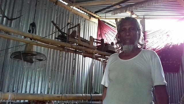 মোহাম্মদ আলীর তাঁতযন্ত্রের সামনে তাঁতি ওয়াজউদ্দিন মুন্সি। ছবি: কাজী আলিম-উজ-জামান