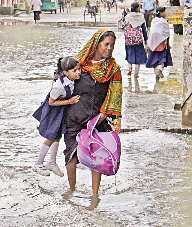 চট্টগ্রামের আগ্রাবাদ সিডিএ আবাসিক এলাকার সকাল ৭টা ৪০ মিনিটের চিত্র। এক শিশু শিক্ষার্থীকে কোলে করে নিয়ে যাচ্ছেন অভিভাবক। এলাকার হাতে খড়ি স্কুল অ্যান্ড কলেজের সামনে থেকে তোলা ছবি l প্রথম আলো