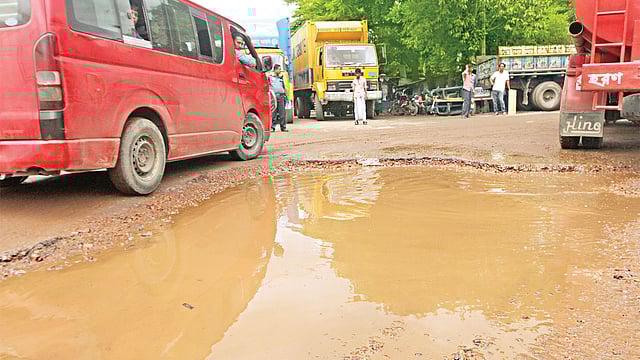 সড়কের গর্তে জমেছে বৃষ্টির পানি। গতকাল দুপুরে চট্টগ্রাম নগরের আগ্রাবাদ বারেক বিল্ডিং এলাকা থেকে তোলা ছবি l প্রথম আলো