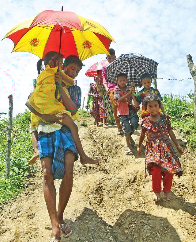 জ্বরে আক্রান্ত এক শিশুকে কোলে করে পাহাড়চূড়ার ত্রিপুরাপাড়া থেকে হাসপাতালে নেওয়া হচ্ছে। গতকাল দুপুরে চট্টগ্রামের সীতাকুণ্ডের ত্রিপুরাপাড়া থেকে তোলা ছবি l প্রথম আলো