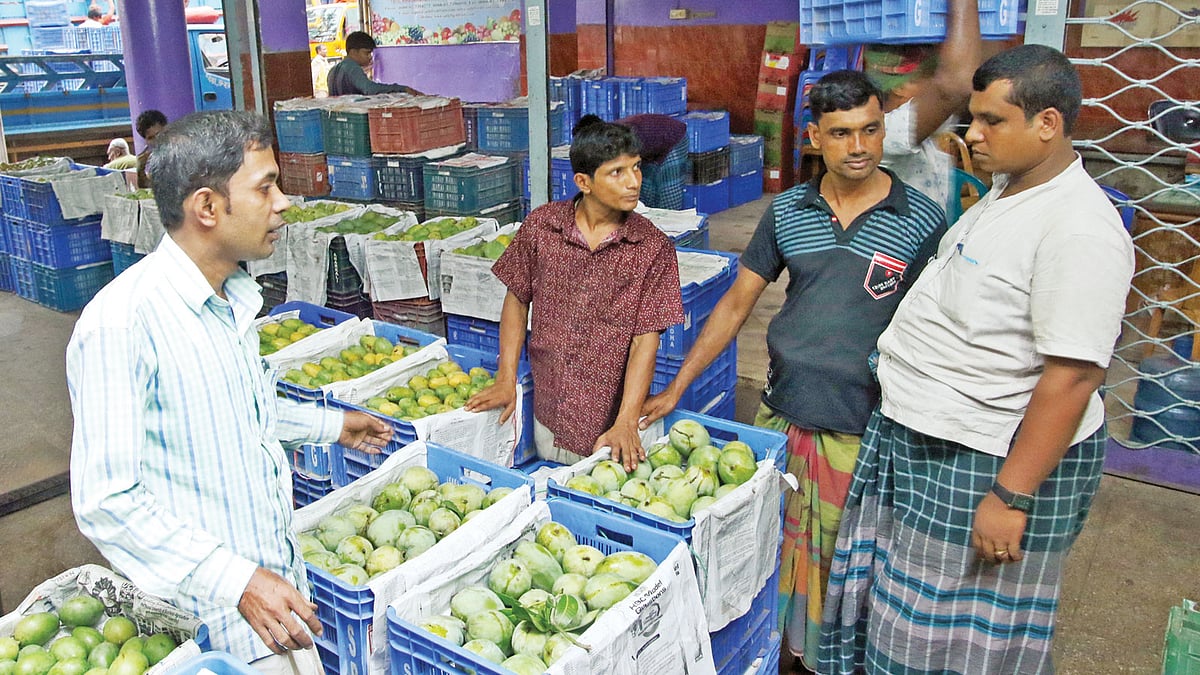 পুরান ঢাকার বাদামতলী ফলের আড়তে আমের দরদাম করছেন ক্রেতারা। ছবিটি গতকাল তোলা l প্রথম আলো