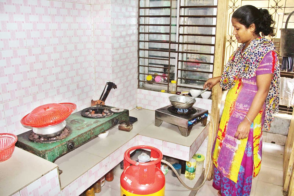 পাইপলাইনের গ্যাস না থাকায় সিলিন্ডারের গ্যাসে পৃথক চুলায় রান্না করছেন এক নারী। ছবিটি গত মঙ্গলবার সকালে মানিকগঞ্জ পৌর এলাকার গঙ্গাধরপট্টি মহল্লা থেকে তোলা l প্রথম আলো
