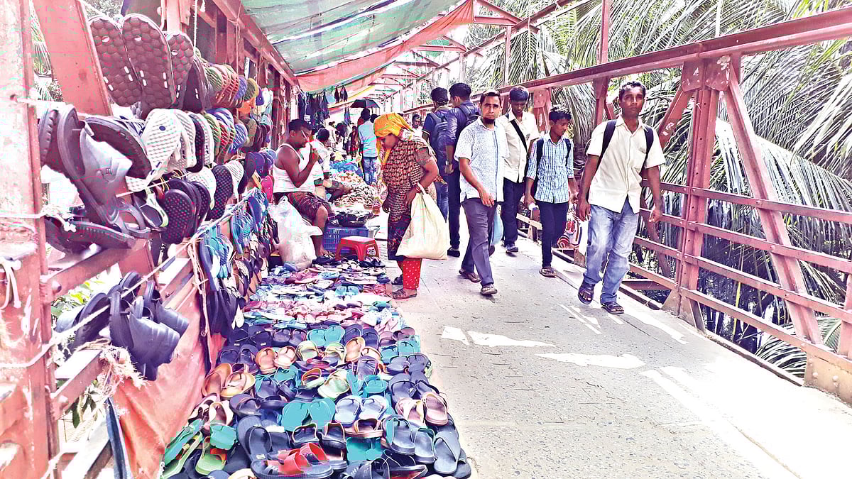 কমলাপুরের এই পদচারী-সেতুতে বাজার বসানোর কারণে ভোগান্তি পোহাতে হচ্ছে পথচারীদের। ছবিটি গত বুধবার তোলা l প্রথম আলো