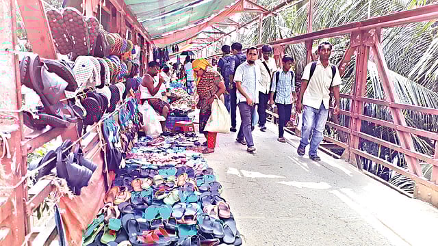কমলাপুরের এই পদচারী-সেতুতে বাজার বসানোর কারণে ভোগান্তি পোহাতে হচ্ছে পথচারীদের। ছবিটি গত বুধবার তোলা l প্রথম আলো