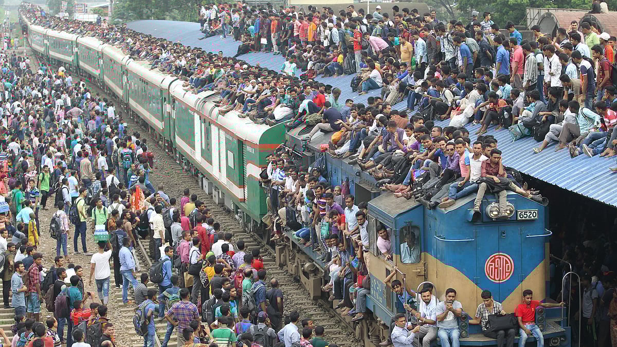 নাড়ির টানে বাড়িমুখী মানুষ। আজ বৃহস্পতিবার রেলওয়ে স্টেশনে যাত্রীদের চাপ ছিল। অনেকে ঝুঁকি নিয়ে ছাদে উঠে গ্রামের বাড়ি উদ্দেশে রওনা হন। ছবিটি দুপুরে বিমানবন্দর রেলস্টেশন থেকে তোলা। ছবি: সাজিদ হোসেন