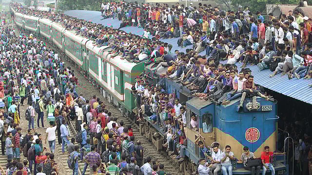 নাড়ির টানে বাড়িমুখী মানুষ। আজ বৃহস্পতিবার রেলওয়ে স্টেশনে যাত্রীদের চাপ ছিল। অনেকে ঝুঁকি নিয়ে ছাদে উঠে গ্রামের বাড়ি উদ্দেশে রওনা হন। ছবিটি দুপুরে বিমানবন্দর রেলস্টেশন থেকে তোলা। ছবি: সাজিদ হোসেন