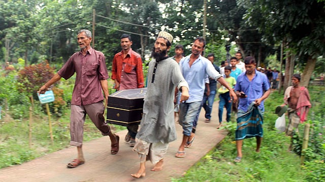 টাঙ্গাইল কেন্দ্রীয় কবরস্থানের কবর থেকে লাশ তুলে কফিনে করে নিয়ে যাওয়া হচ্ছে বাড়ির উদ্দেশে। ছবি: কামনাশীষ শেখর