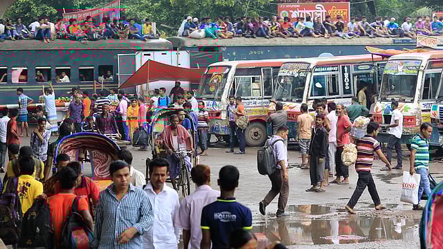 সায়েদাবাদ বাস টার্মিনালে যাত্রীদের ভিড়। অন্যদিকে ট্রেনের ছাদে করে বাড়ি ফিরছেন যাত্রীরা। ছবিটি বৃহস্পতিবার দুপুরে তোলা। ছবি: হাসান রাজা