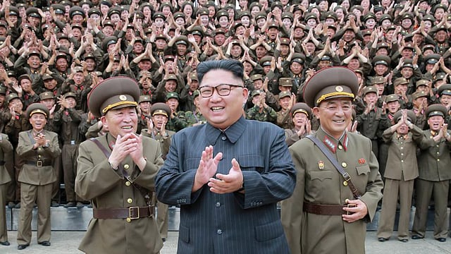 সেনা কর্মকর্তাদের মাঝে হাস্যোজ্জ্বল উত্তর কোরিয়ার নেতা কিম জং উন। ছবি: রয়টার্স