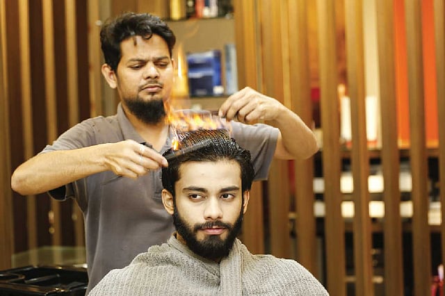 আগুন জ্বলা অবস্থায় চিরুনি দিয়ে আঁচড়ানো আর কাঁচি দিয়ে ছাঁটা চলতে থাকে একসঙ্গে। মডেল: আয়াজ, কৃতজ্ঞতা: অ্যাডোনিস, ছবি: সুমন ইউসুফ