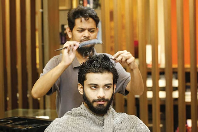 রাসায়নিক লাগানোর পর চুল আঁচড়ে নেওয়া হচ্ছে