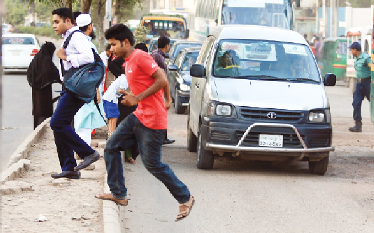 এভাবে রাস্তা পার হলে দুর্ঘটনার আশংকা থেকেই যায়। ছবি: প্রথম আলো