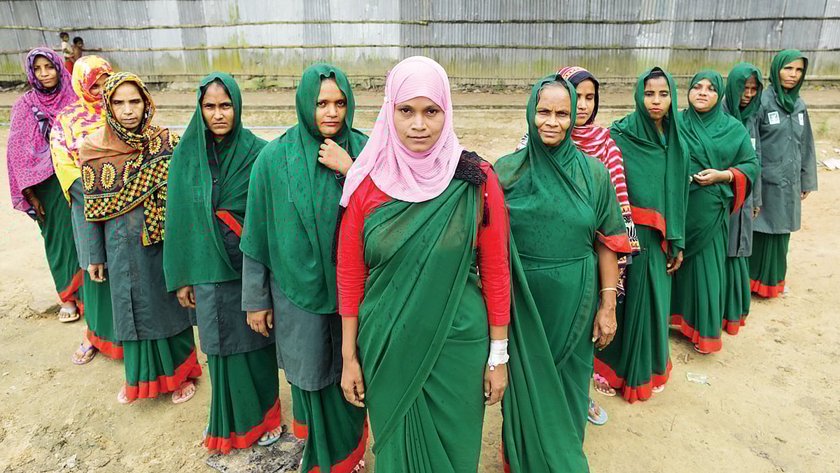 কেরুনতলীতে বনরক্ষী দলের সঙ্গে নিজের বাড়ির সামনে খুরশিদা বেগম। ছবি: সৌরভ দাশ