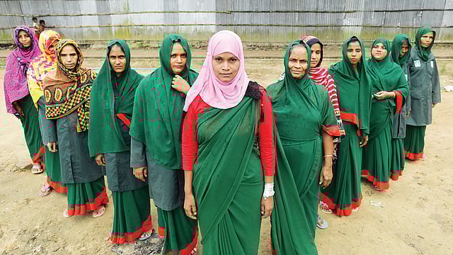 কেরুনতলীতে বনরক্ষী দলের সঙ্গে নিজের বাড়ির সামনে খুরশিদা বেগম। ছবি: সৌরভ দাশ