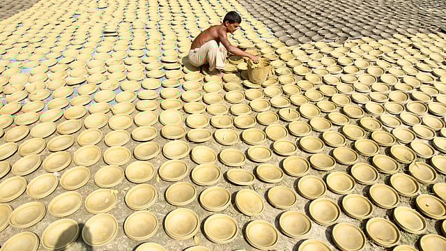 রোদেলা সকালে দইয়ের সরা রং করছেন অনুকূল চন্দ্র পাল। শেখেরকোলা, বগুড়া সদর, ৪ নভেম্বর। ছবি: সোয়েল রানা
