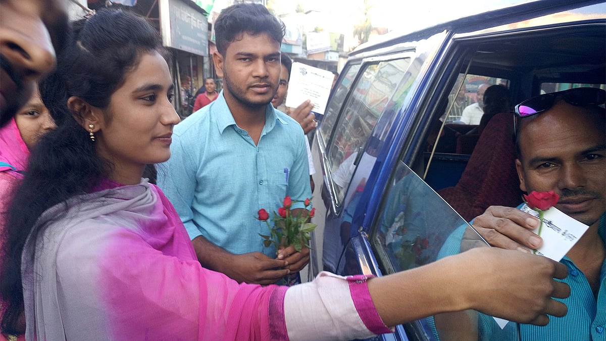 বদরগঞ্জ-রংপুর সড়কে চলাচল করা শতাধিক যানবাহনের চালকের হাতে গোলাপ ফুল ও নিরাপদে যান চালানোর জন্য সচেতনতামূলক কার্ড তুলে দিচ্ছেন বদরগঞ্জ বন্ধুসভার সদস্যরা। ছবি: আলতাফ হোসেন