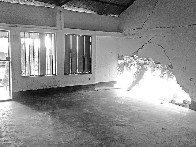 পানচাইল সরকারি প্রাথমিক বিদ্যালয়ের একটি শ্রেণিকক্ষের দেয়াল ও মেঝে ভেঙে পুকুরে পড়ে গেছে l ছবি: প্রথম আলো