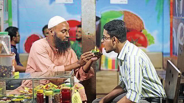 একজনের মুখে জ্বলন্ত পান তুলে দিচ্ছেন আবদুল জলিল হাওলাদার। ছবি: লেখক