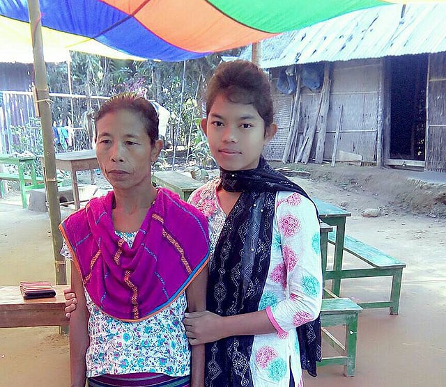 বাড়ির উঠানে মারিয়া মান্দা ও তার মা। ছবি: প্রথম আলো