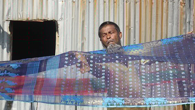 নিজের তৈরি জামদানি শাড়িতে ভাতের মাড় লাগাচ্ছেন আলী হোসেন। একেকটি জামদানি তৈরি করতে তাঁর এক সপ্তাহ থেকে এক মাস সময় লাগে। একেকটি সাধারণ জামদানি বিক্রি করেন চার থেকে ছয় হাজার টাকায়। জামদানিপল্লি, রূপগঞ্জ, নারায়ণগঞ্জ, ৩১ ডিসেম্বর। ছবি: আবদুস সালাম