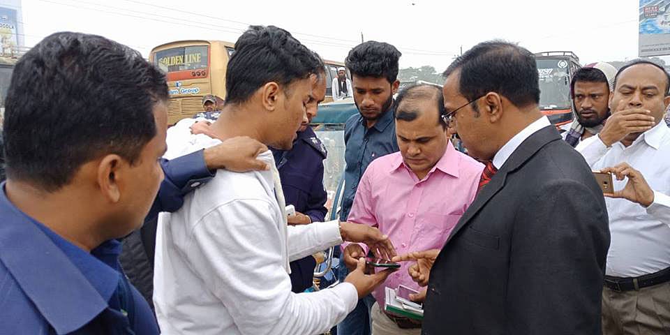 বাস থেকে নামিয়ে জোবাইদুলের মোবাইলে পাওয়া প্রশ্নপত্র খতিয়ে দেখছে জেলা প্রশাসন কর্তৃপক্ষ। ছবি: মাদারীপুর জেলা প্রশাসনের ফেসবুক পেজ থেকে