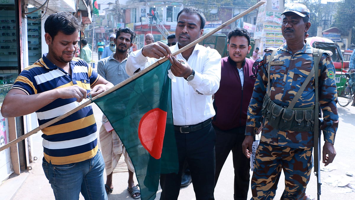 জাতীয় পতাকা সঠিকভাবে ব্যবহার শেখাচ্ছেন নির্বাহী ম্যাজিস্ট্রেট মো. মনিরুজ্জামান। ব্রাহ্মণবাড়িয়া, ২১ ফেব্রুয়ারি, ২০১৮। ছবি: প্রথম আলো