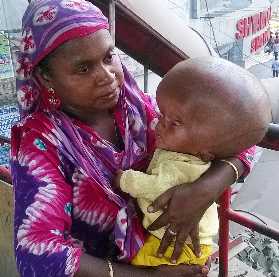 শ্যামলী পদচারী-সেতুর ওপর ছেলেকে নিয়ে মা মরিয়ম। ছবি: প্রথম আলো