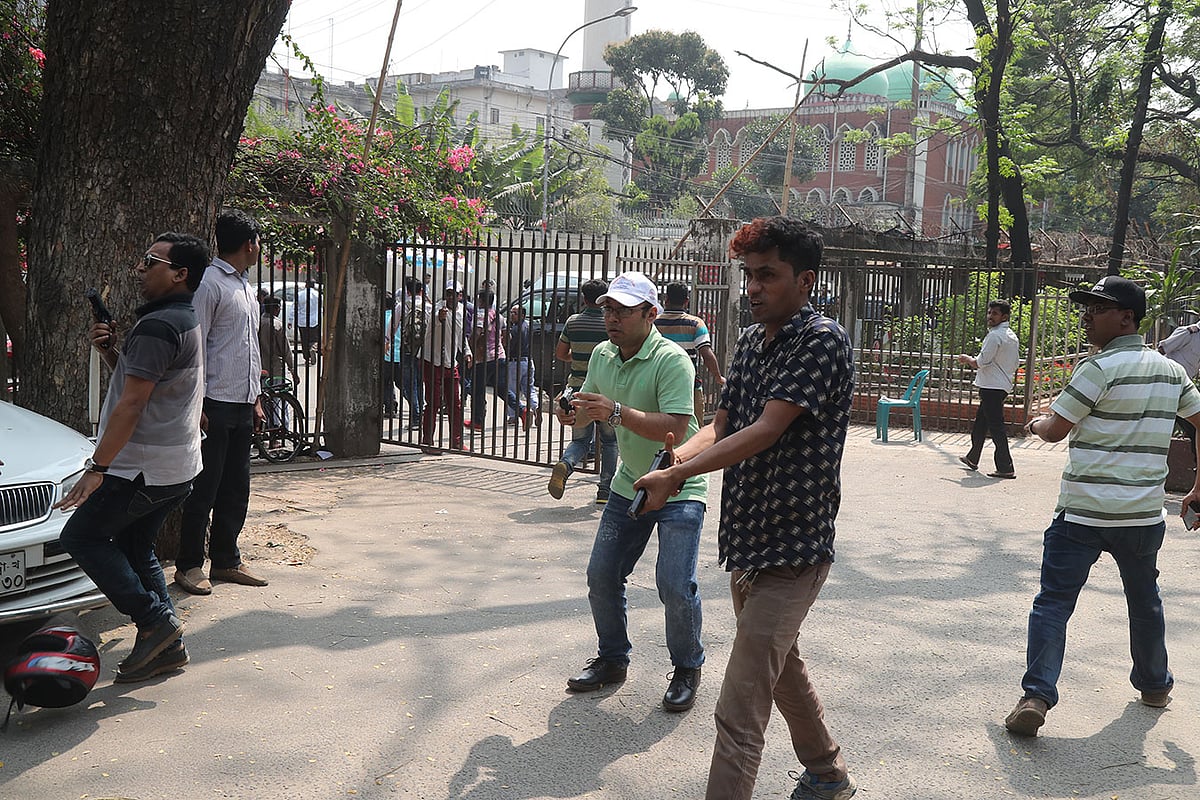 সাদাপোশাকে অস্ত্র হাতে বিএনপি কর্মীদের ধাওয়া। ছবি: সাজিদ হোসেন