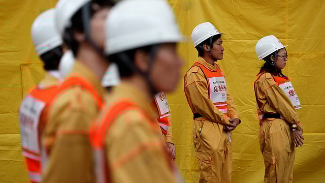 নিহত ব্যক্তিদের স্মরণে দাঁড়িয়ে নীরবতা পালন করছেন শ্রমিকেরাও। টোকিও, জাপান, ১১ মার্চ। ছবি: রয়টার্স
