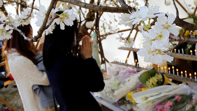 নিহত ব্যক্তিদের জন্য প্রার্থনা করছেন অনেকে। টোকিও, জাপান, ১১ মার্চ। ছবি: রয়টার্স