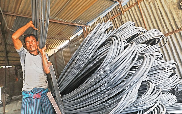সরবরাহের জন্য একটি দোকান থেকে রড বের করছেন একজন শ্রমিক। গতকাল নারায়ণগঞ্জের ফতুল্লায়।  ছবি: প্রথম আলো