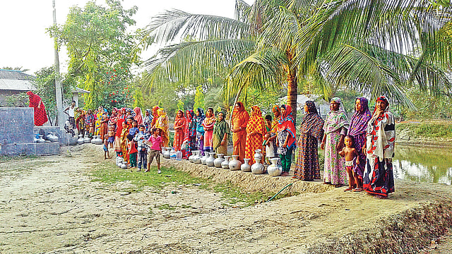 খাওয়ার পানির জন্য অপেক্ষা। সাতক্ষীরার শ্যামনগর উপজেলার মুন্সিগঞ্জ ইউনিয়নের মুনসুরের গ্যারেজ এলাকায় ‘পন্ড–স্যান্ড–ফিলটার’ পদ্ধতিতে আসা পানি সংগ্রহের জন্য অপেক্ষায় বিভিন্ন গ্রামের মানুষ। গত সোমবার ছবিটি তোলা। প্রথম আলো