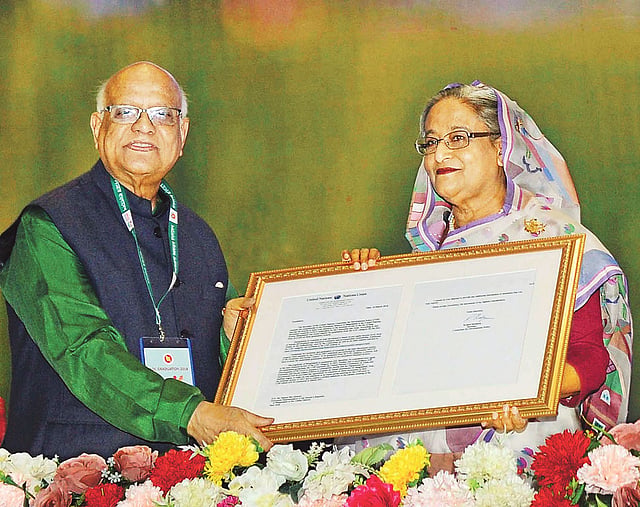 রাজধানীর বঙ্গবন্ধু আন্তর্জাতিক সম্মেলন কেন্দ্রে গতকাল প্রধানমন্ত্রীকে সংবর্ধনা ও সপ্তাহব্যাপী অনুষ্ঠানমালার উদ্বোধনী অনুষ্ঠানে বাংলাদেশের উন্নয়নশীল দেশে উত্তরণের সুপারিশপত্রের রেপ্লিকা প্রধানমন্ত্রী শেখ হাসিনার হাতে তুলে দেন অর্থমন্ত্রী আবুল মাল আবদুল মুহিত।  ছবি: পিআইডি