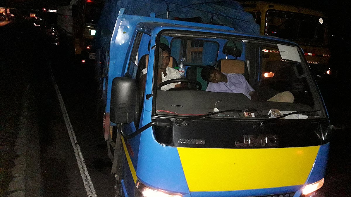 ঢাকা-চট্টগ্রাম মহাসড়কে দাউদকান্দিতে প্রায় ৪০ কিলোমিটার যানজট সৃষ্টি হয়েছে। শুক্রবার রাত সাড়ে আটটার দিকে মহাসড়কের দাউদকান্দির গৌরীপুরে থেমে থাকা একটি ট্রাকে চালকের সহকারীকে ঘুমিয়ে থাকতে দেখা যায়। ছবি: আবদুর রহমান