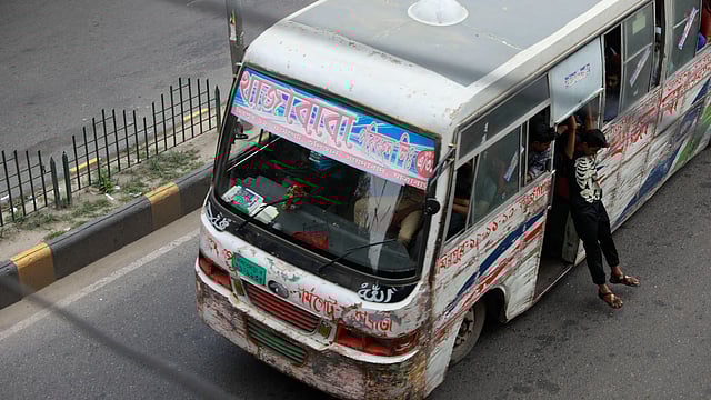 বাসের ফটকে ঝুলে আছেন বাসের সহকারী। এভাবে ঘটে মর্মান্তিক দুর্ঘটনা। ইঞ্জিনিয়ার্স ইনস্টিটিউশন ভবন এলাকা, ঢাকা, সাম্প্রতিক ছবি। ছবি: শুভ্র কান্তি দাশ