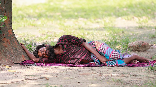 গাছের ছায়ায় গামছা বিছিয়ে একটু ঘুমিয়ে নেওয়া। সোহরাওয়ার্দী উদ্যান, ঢাকা, ৮ মে। ছবি: শুভ্র কান্তি দাশ