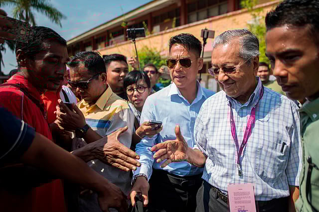 ভোট দেওয়ার পর কেন্দ্রের উপস্থিত সমর্থকদের সঙ্গে কুশল বিনিময় করছেন মাহাথির মোহাম্মদ। রাজনীতির মঞ্চে ফিরেই নিজের দল ও একসময়ের শিষ্যের বিরুদ্ধে দাঁড়িয়েছেন তিনি। মালয়েশিয়া, ৯ মে। ছবি: এএফপি