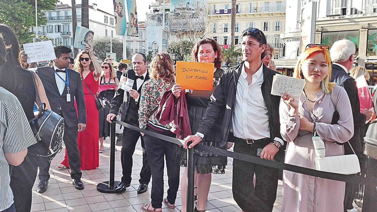 শুধু একটি টিকিটের জন্য এভাবে প্ল্যাকার্ড হাতে দাঁড়িয়ে থাকেন সিনেমাপ্রেমীরা। ছবি: প্রথম আলো